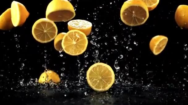 Кусочки Лимона Капельками Воды Взлетают Падают Стол Черном Фоне Снято — стоковое видео