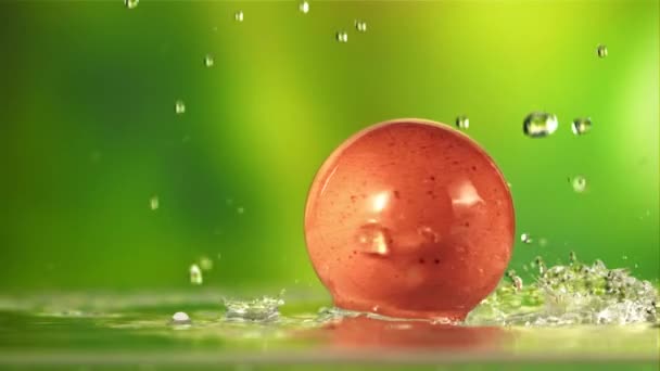 Woda Kapie Obracające Się Jajko Zielonym Tle Nagrywane Szybkiej Kamerze — Wideo stockowe