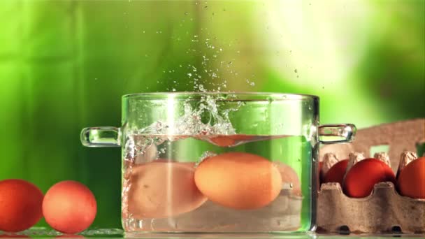 Huevos Con Salpicaduras Caen Una Olla Agua Sobre Fondo Verde — Vídeos de Stock