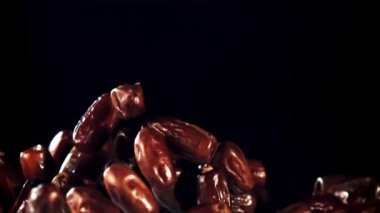 Tarihler yükselir ve uçuşlarda döner. Siyah bir arka planda. 1000 fps hızla yüksek hızlı bir kamerayla çekildi..