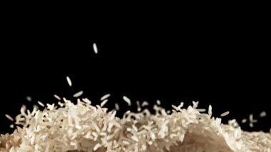 Pirinç yükselir ve düşer. Pirinç sosu. Siyah bir arka planda. Film yavaş çekimde 1000 fp..
