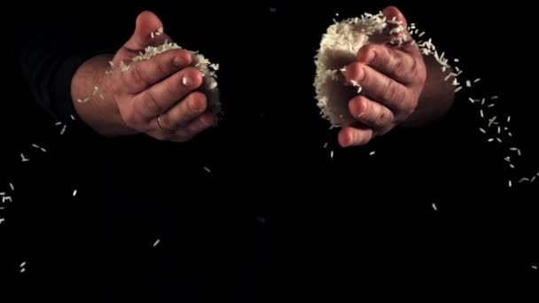 Männerhände Werfen Eine Handvoll Rohen Zerbröselten Reis Auf Schwarzem Hintergrund — Stockvideo