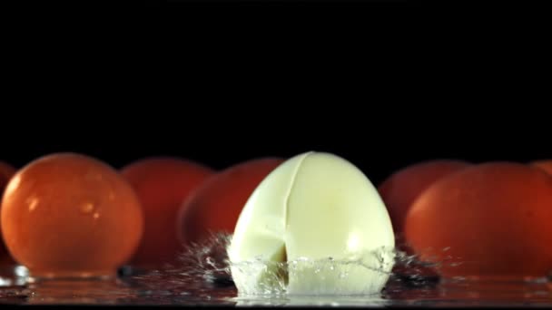 Uovo Sodo Cade Sul Tavolo Rompe Metà Uno Sfondo Nero — Video Stock