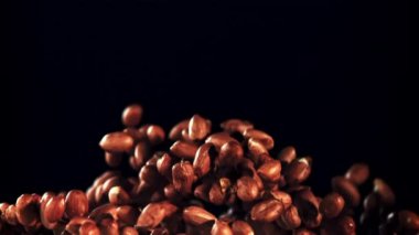 Fıstıklar yükselir ve düşer. Siyah bir arka planda. Film yavaş çekimde 1000 fp..