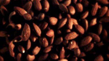 Bademler havada uçar ve döner. Üst Manzara. Makro arka plan. 1000 fps hızla yüksek hızlı bir kamerayla çekildi..