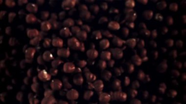 Fındıklar yükselir ve düşer. Üst Manzara. Siyah bir arka planda. Film yavaş çekimde 1000 fp..