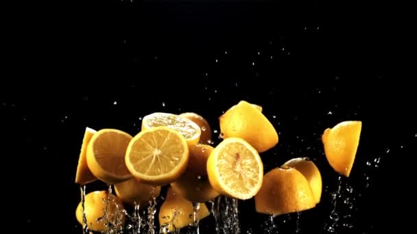 Половинки Свежих Лимонов Капельками Воды Взлетают Вращаются Полете Черном Фоне — стоковое видео
