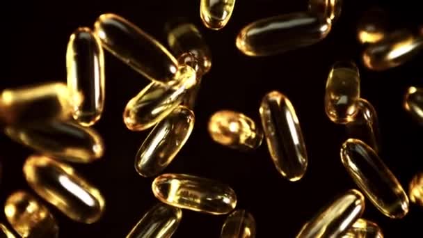 Las Cápsulas Vitamínicas Omega Giran Vuelo Sobre Fondo Negro Filmado — Vídeos de Stock
