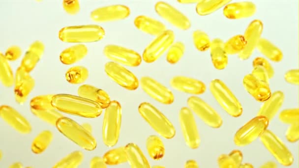 Omega Vitaminecapsules Roteren Langzaam Tijdens Vlucht Een Witte Achtergrond Gefilmd — Stockvideo