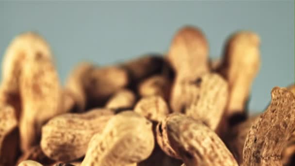 Erdnüsse Der Schale Fliegen Auf Und Auf Blauem Hintergrund Gefilmt — Stockvideo