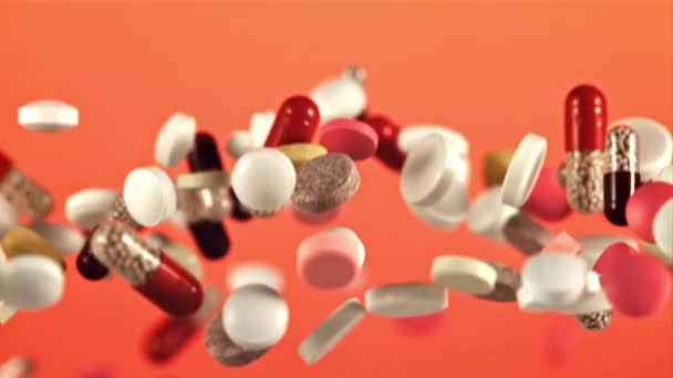 Különböző Típusú Tabletták Repülnek Fel Esnek Piros Háttérrel 1000 Fps — Stock videók