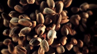 Fıstıklar kalkar ve düşer. Üst Manzara. Siyah bir arka planda. Film yavaş çekimde 1000 fp..