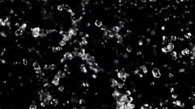 Uçan bir damla suyun hareketi. Üst Manzara. Siyah bir arka planda. 1000 fps hızla yüksek hızlı bir kamerayla çekildi..