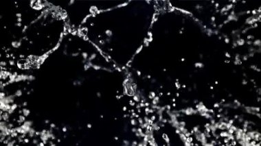 Uçan bir damla suyun hareketi. Üst Manzara. Siyah bir arka planda. 1000 fps hızla yüksek hızlı bir kamerayla çekildi..