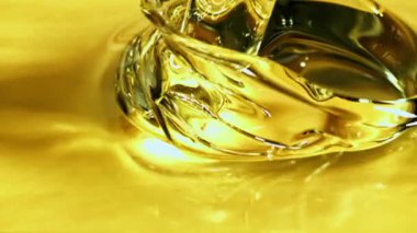 Bir jet zeytinyağı hava kabarcıklarıyla doluyor. Makro arka plan. Film yavaş çekimde 1000 fp..