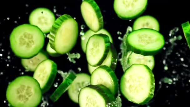 Pieces Fresh Cucumber Splashes Water Fly Rotate Flight Black Background — Stock Video