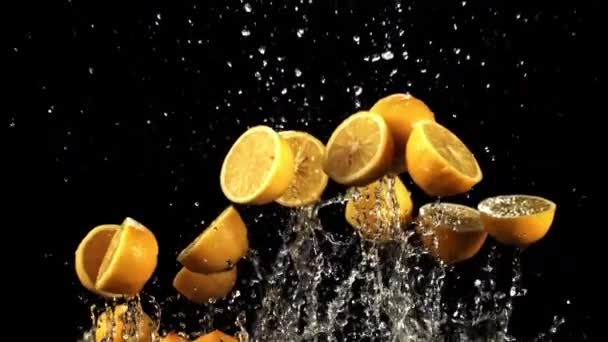Zitronenstückchen Mit Wassertropfen Fliegen Auf Und Auf Schwarzem Hintergrund Gefilmt — Stockvideo