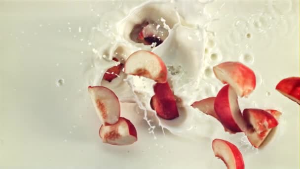 一片片的红桃掉进牛奶里 顶部视图 在白色的背景上拍成电影是慢动作1000 Fps — 图库视频影像