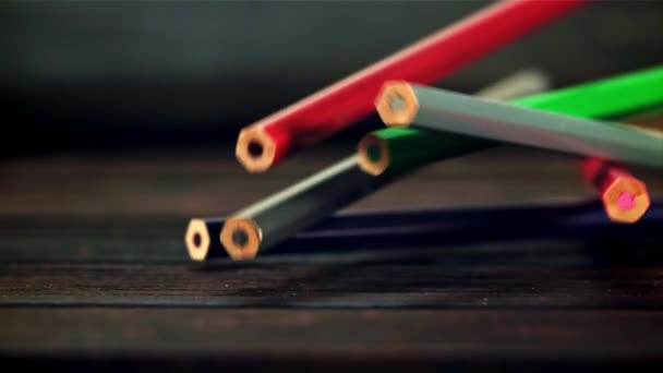 Kolorowe Ołówki Spadają Drewniany Stół Ciemnym Tle Nagrywane Jest Zwolnionym — Wideo stockowe