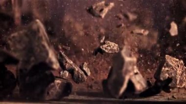 Çikolata parçaları düşer ve uçarken döner. Karanlık bir arka plana karşı. Film yavaş çekimde 1000 fp.. 