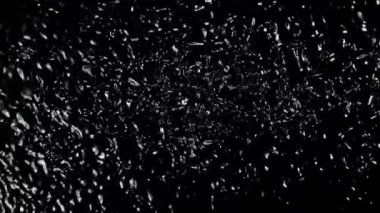 Su damlaları yükselir ve düşer. Üst Manzara. Siyah bir arka planda. Film yavaş çekimde 1000 fp..