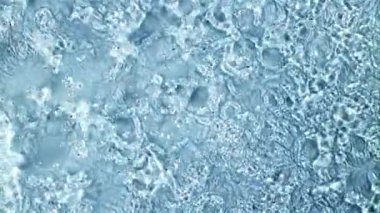 Su damlacıkları yükselir ve düşer. Üst Manzara. Mavi arka planda. 1000 fps hızla yüksek hızlı bir kamerayla çekildi..