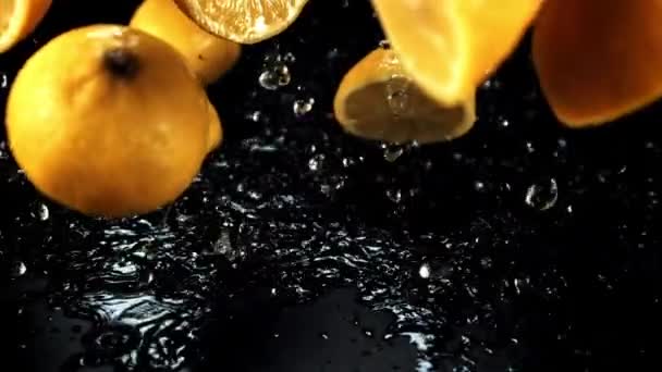 Μισά Ζουμερά Λεμόνια Πέφτουν Πιτσιλιές Νερού Μαύρο Φόντο Ταινία Είναι — Αρχείο Βίντεο