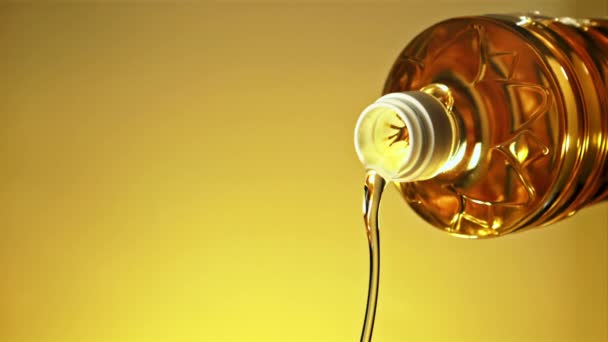 Бутылки Льется Поток Оливкового Масла Жёлтом Фоне Снято Высокоскоростную Камеру — стоковое видео