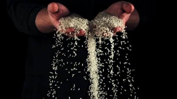Nevařená Rýže Padá Pánských Rukou Černém Pozadí Natočeno Vysokorychlostní Kameře — Stock video