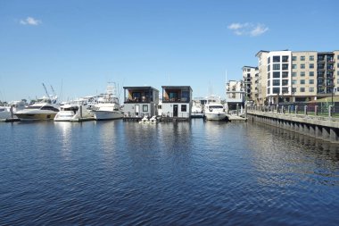Wilmington NC şehir merkezindeki Cape Fear nehri boyunca nehir kenarında bir marina, yüzen evler ve tekneler.                               