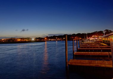 Günbatımında Southport Kuzey Carolina nehir kıyısında tekne rıhtımları ve deniz ürünleri restoranları var.