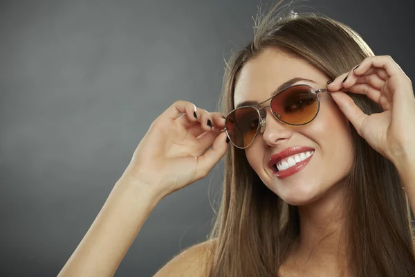 Vrouw dragen van een zonnebril en glimlachen — Stockfoto