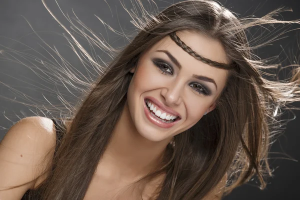 Menina sorridente com cabelo soprando — Fotografia de Stock