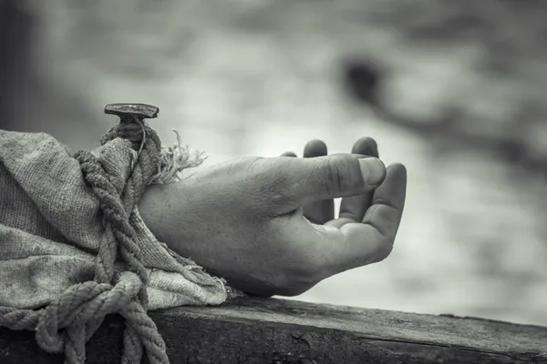 Nailed hand on wooden cross — Stock Photo, Image