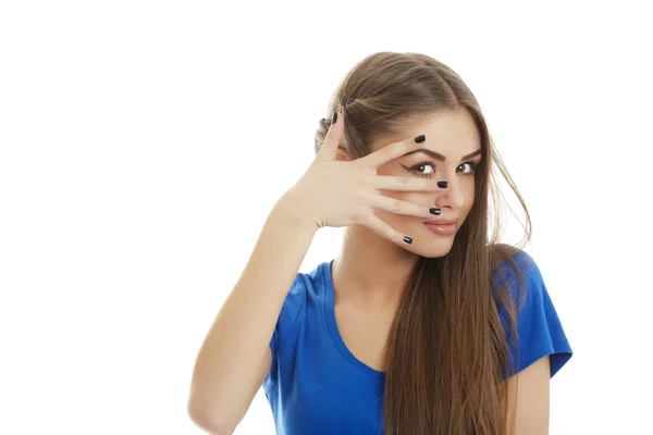 Mujer joven mirando a través de los dedos — Foto de Stock