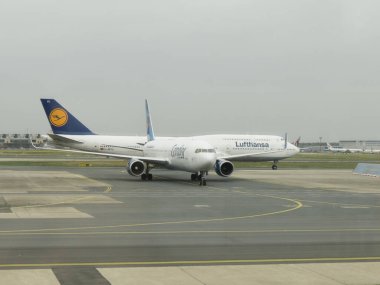 FRANKFURT AM MAIN, ALMANY - CRCA Nisan 2022: Lufthansa Boeing 747 taksi ve Akbaba Boeing 737 park halindeyken