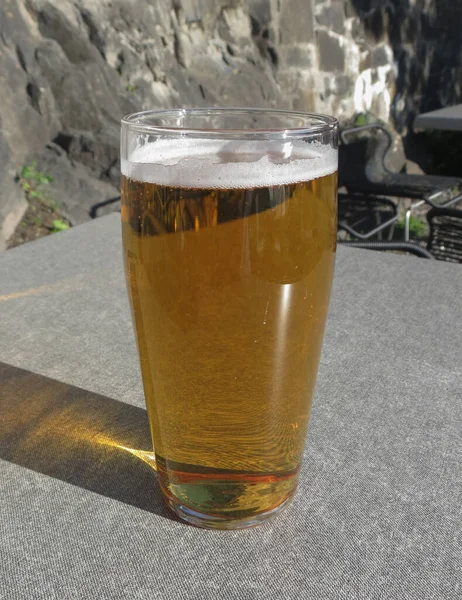 石のテーブルを屋外でビールのグラス — ストック写真