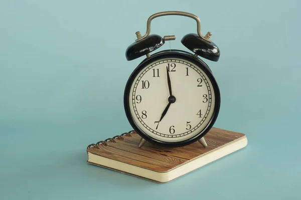 Reloj despertador analógico clásico de lujo negro sobre una mesa