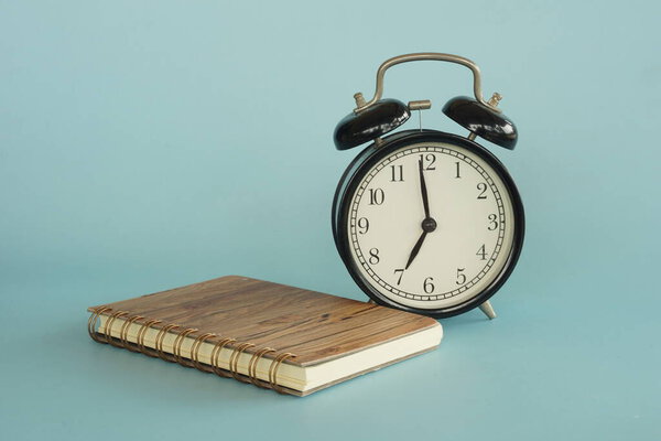 book and alarm clock on the table