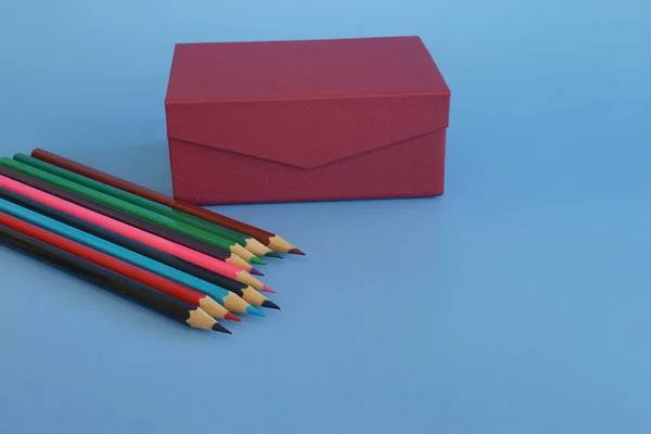 蓝色背景上的彩色铅笔和礼品盒 — 图库照片
