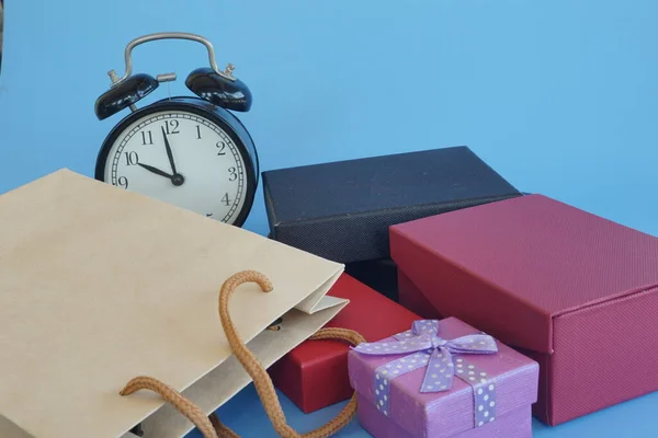 木制背景上的闹钟和礼品盒 — 图库照片