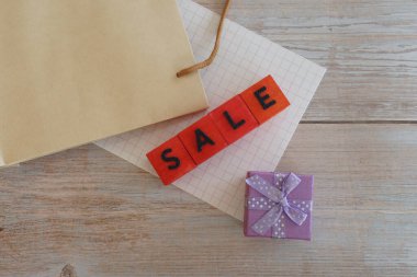 İndirim. Kese kağıdı ve hediye paketi masanın üstünde.