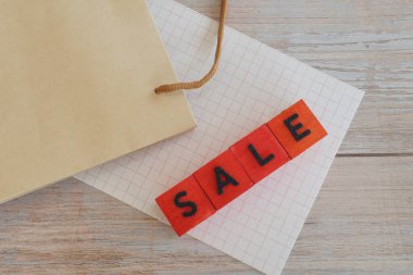 İndirim. Kese kağıdı ve hediye paketi masanın üstünde.