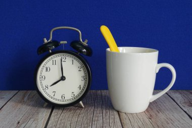 Bardaklar ve çalar saat masanın üzerinde.