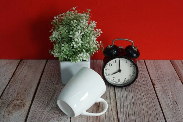 目覚まし時計と鉢植えの花がテーブルの上に — ストック写真