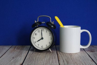 Çalar saat ve masada bir kupa.