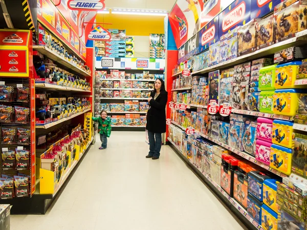 Jongen en moeder winkelen in een grote speelgoedwinkel — Stockfoto