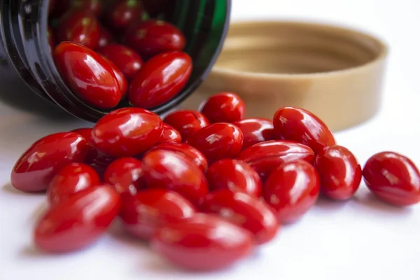 Rode pillen buiten de groene fles — Stockfoto