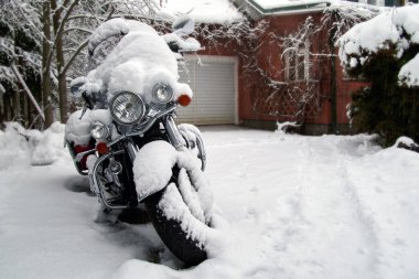 Evin bahçesindeki karın altında motosiklet..