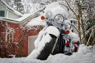Evin bahçesindeki karın altında motosiklet..